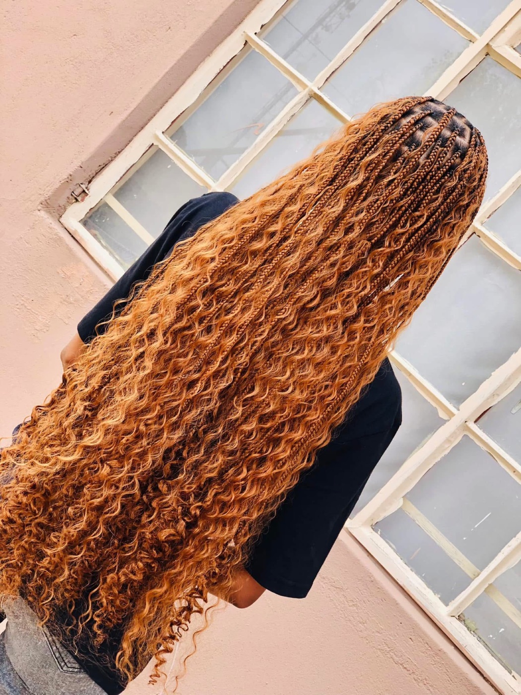 Long copper goddess braids with curly ends, seen from behind